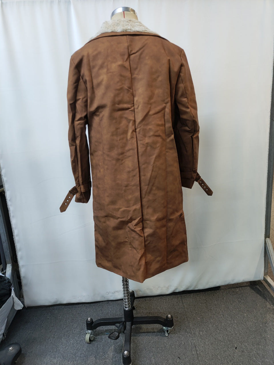 Back view of brown suede long coat with white shearling collar on dress form stand