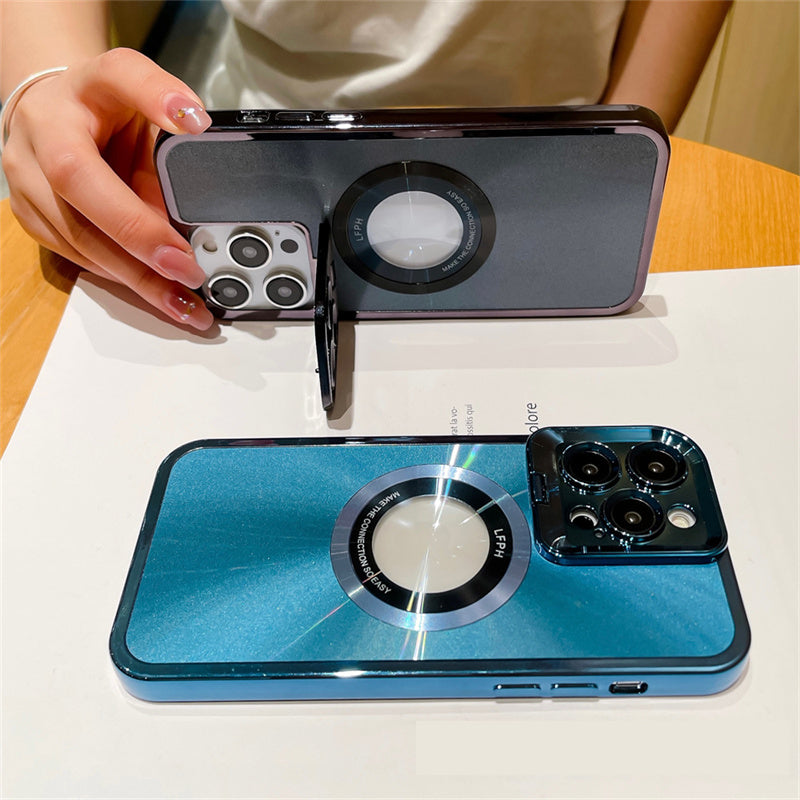 Two iPhones with shiny blue and gray protective cases featuring large circular metal rings and triple camera setups on a wooden table
