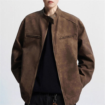 Close-up of a person wearing a brown suede bomber jacket with front zip and black shirt