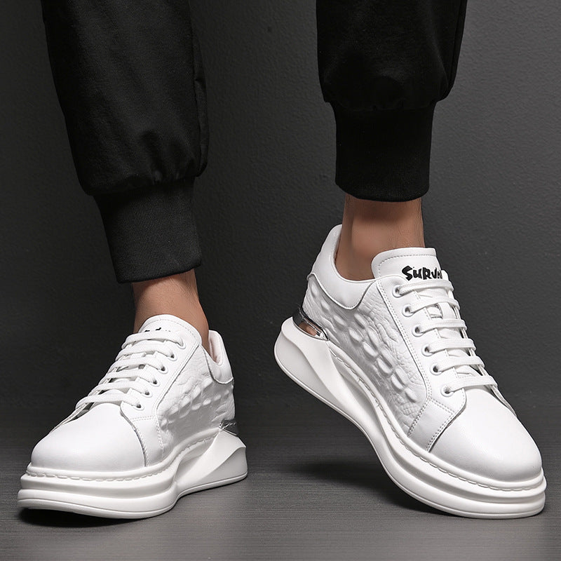White men's leather sneakers with textured side panels and lace-up design, worn with black pants