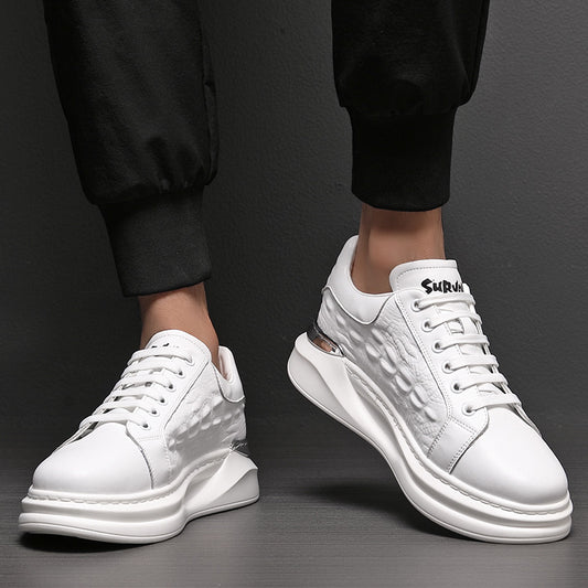White men's leather sneakers with textured side panels and lace-up design, worn with black pants