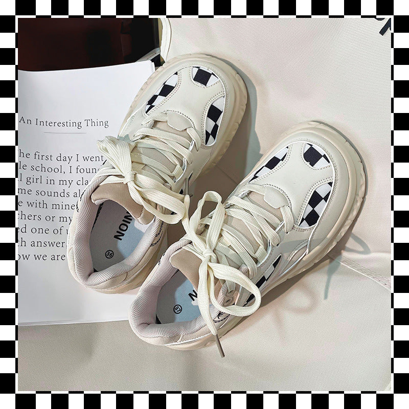 White chunky sneakers with black and white checkerboard pattern, beige padded tongue, white laces