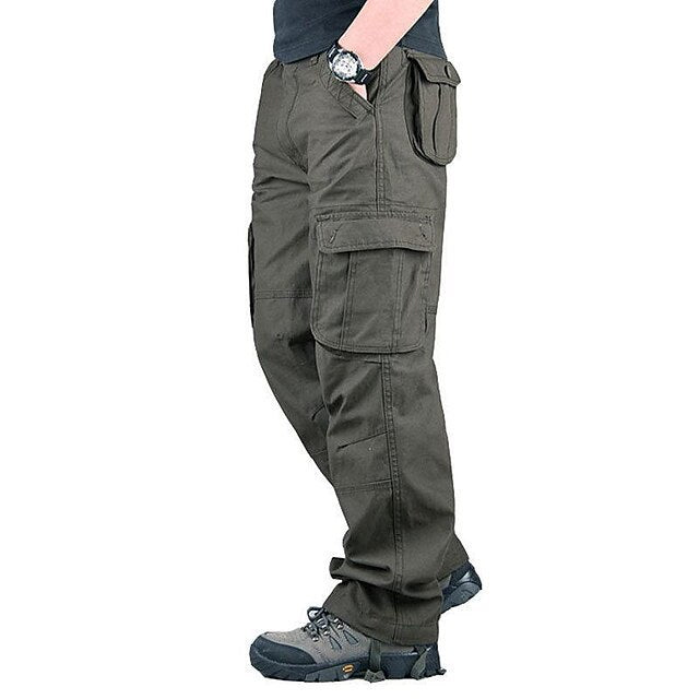 Man wearing dark green cargo pants with multiple pockets and gray outdoor shoes