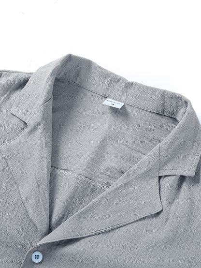 Close-up of light gray textured shirt collar with medium size label and white button detail