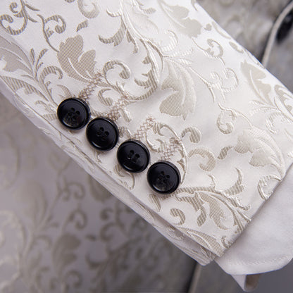 White brocade jacket sleeve with intricate floral pattern and four black buttons