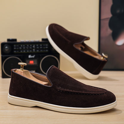 dark brown suede loafers with white soles placed on wooden surface with vintage radio in background