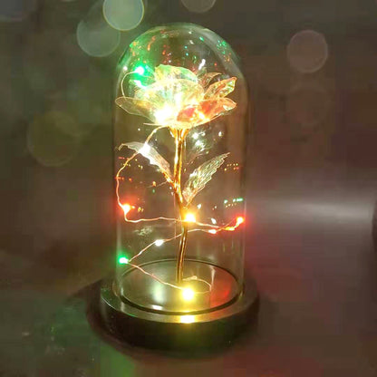 Decorative LED illuminated glass rose encased in a clear glass dome on black base
