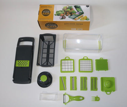 16-piece green and black veggie slicer set with multiple blades, container, and peeler on white background