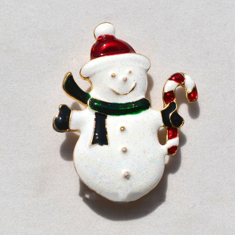 festive snowman pin with red Santa hat, green scarf, black mittens, holding a red and white candy cane