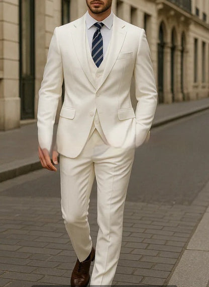 Man walking on city street wearing white three-piece suit with navy striped tie and brown shoes