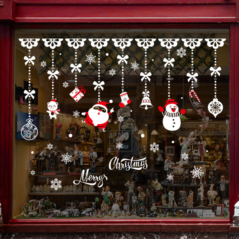 Christmas window decorations with Santa, snowman, gifts, snowflakes, and Merry Christmas text on shop display
