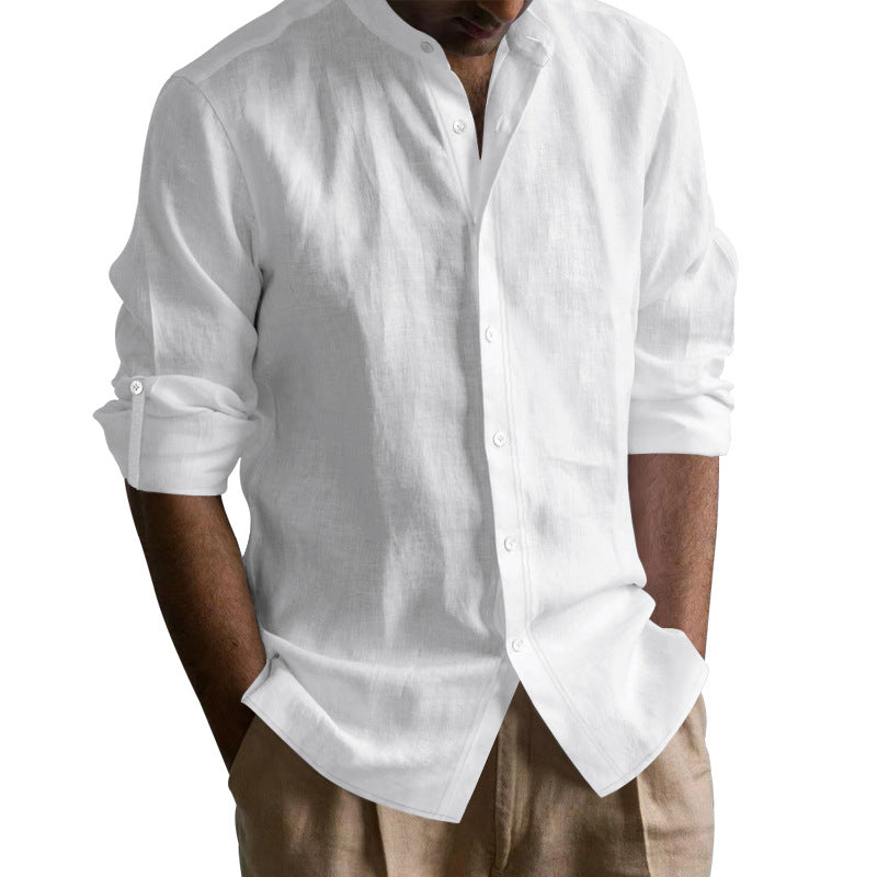 Man wearing casual white linen shirt with rolled-up sleeves and beige pants, hands in pockets