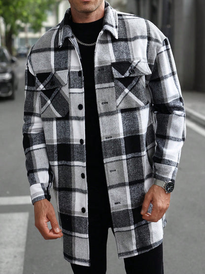 Man wearing black white gray plaid button-up shirt jacket with long sleeves on city street