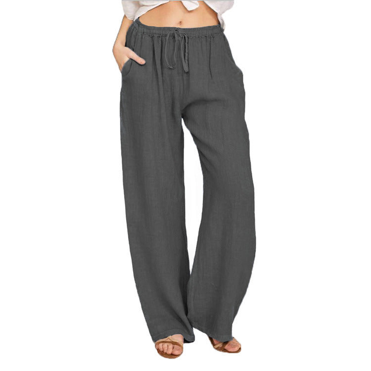 High-waisted charcoal gray wide-leg linen pants with drawstring and pockets, worn with sandals