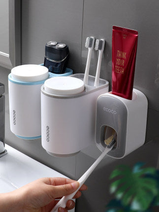 Wall-mounted white bathroom organizer holding toothbrushes, toothpaste, and electric shaver near sink