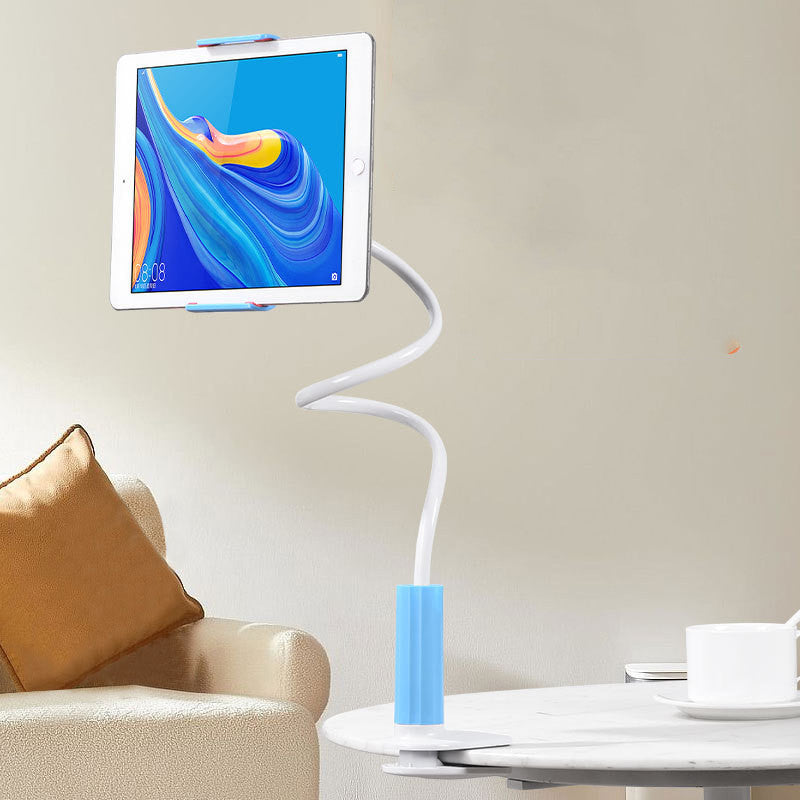 Adjustable tablet holder with flexible white arm and blue clamp mounted on a white table next to a beige sofa with brown cushion