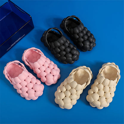 Three pairs of textured bubble design slip-on shoes in black, pink, and beige on blue background