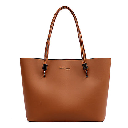 Brown leather tote bag with double handles and Forever Young logo on front