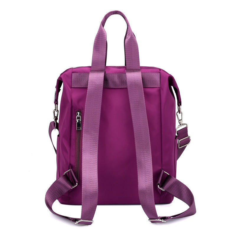 Purple nylon backpack with adjustable shoulder straps and side zipper pocket on white background