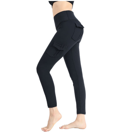 Woman wearing black high-waisted cargo pocket leggings in side view, barefoot on white background