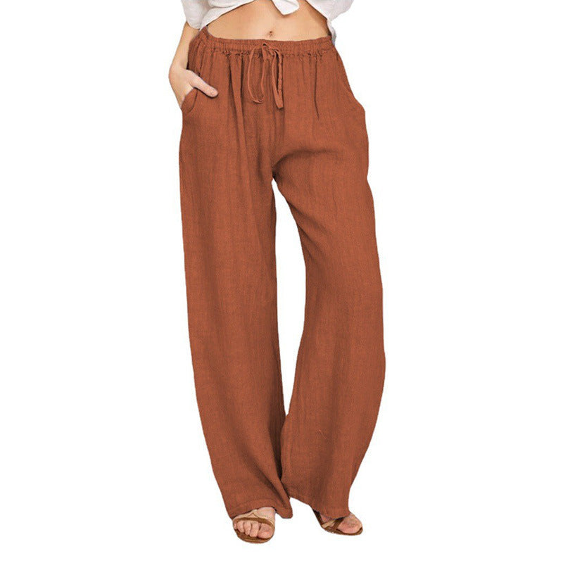 Brown wide-leg linen pants with drawstring waist and pockets, modeled with sandals and white top
