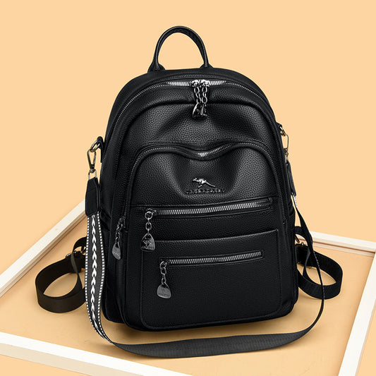 Black leather backpack with multiple zipper pockets and adjustable straps on beige background