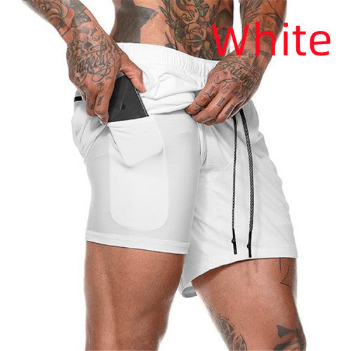 Tattooed man wearing white athletic shorts with inner pocket holding a smartphone