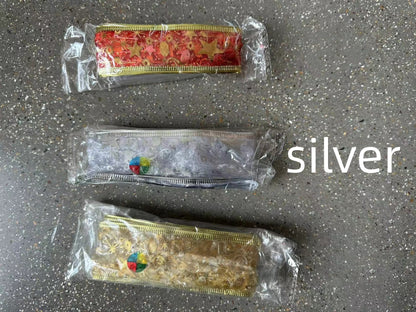 Three decorative ribbon rolls in red, silver, and gold with star patterns, wrapped in clear plastic