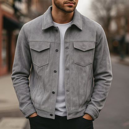 Close-up of man wearing grey suede jacket with front pockets and black buttons over white t-shirt outdoors