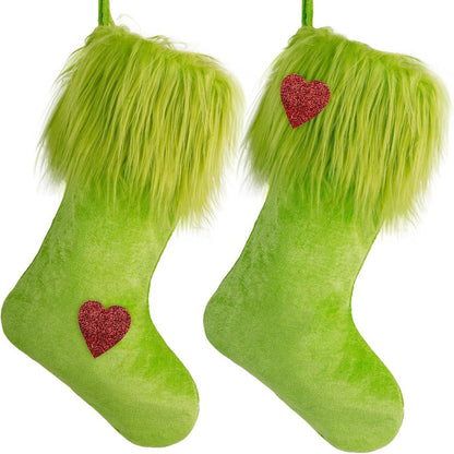 Pair of green Christmas stockings with furry cuffs and red glitter heart decorations