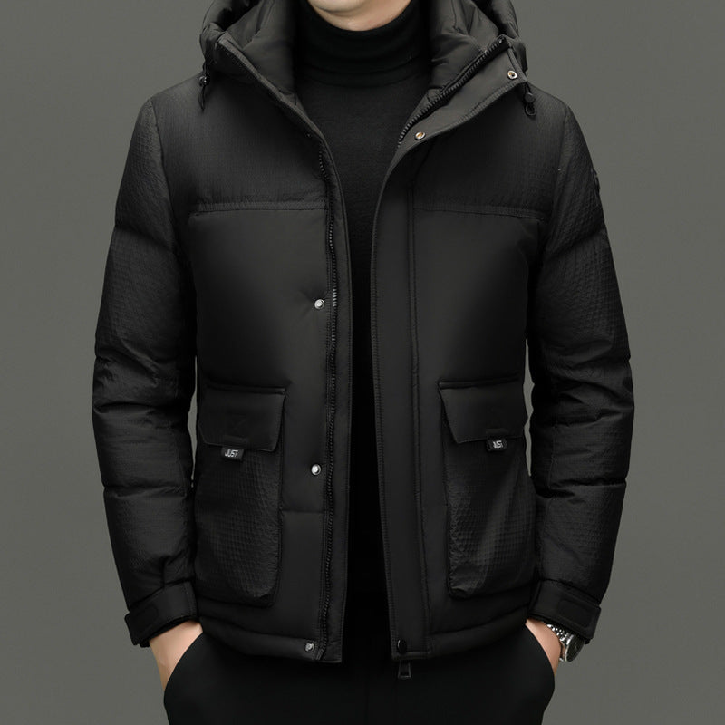Man wearing black padded hooded winter jacket with zip and snap buttons, front pockets, and textured sleeves