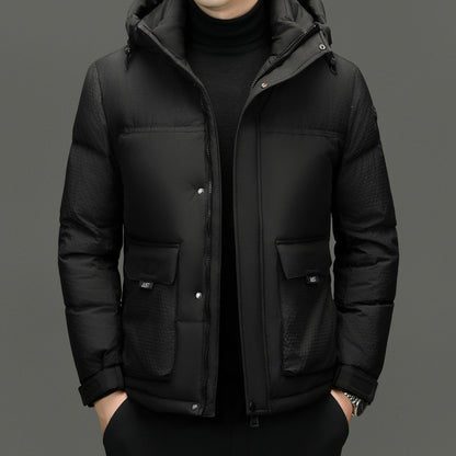 Man wearing black padded hooded winter jacket with zip and snap buttons, front pockets, and textured sleeves