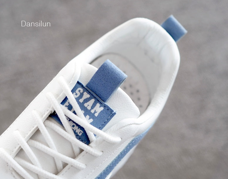 White sneaker with blue accents, white laces, and branding on the tongue label