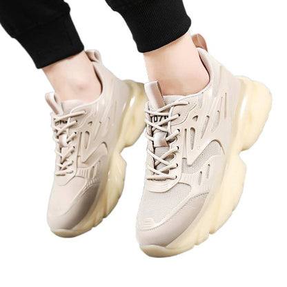 Beige chunky sneakers with thick translucent soles worn with black pants on white background