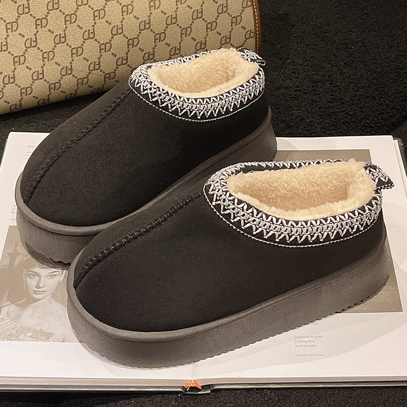 Black slip-on winter slippers with fluffy beige lining and decorative white stitching on edges
