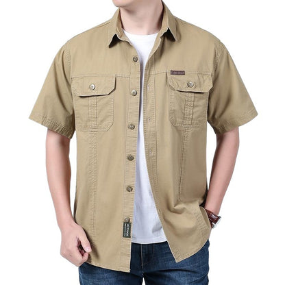 Man wearing beige short-sleeve button-up shirt with chest pockets and white t-shirt underneath