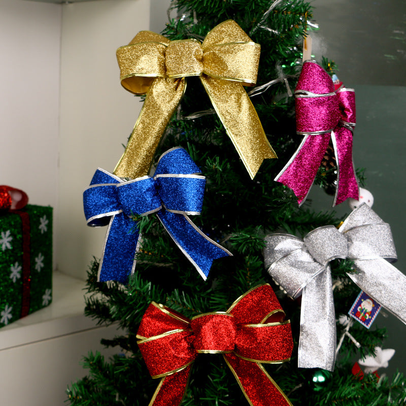Glittery Christmas bows in gold, blue, pink, silver, and red displayed on a green Christmas tree