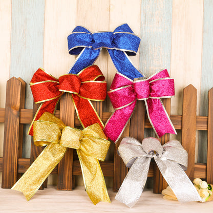 Five glittery bows in blue, red, pink, gold, and silver displayed on wooden fence backdrop