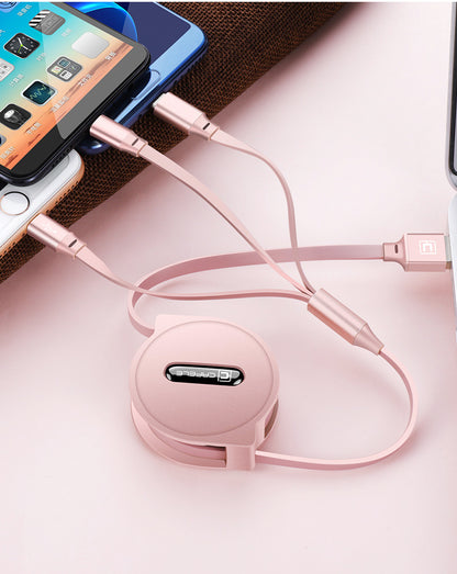Rose gold retractable multi-device charging cable connected to smartphones and laptop on pink surface