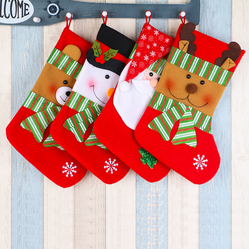 Red Christmas stockings with bear, snowman, Santa, and reindeer designs on wooden background