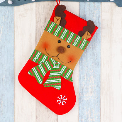 Red Christmas stocking with cute reindeer face, green striped scarf, and snowflake detail