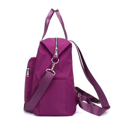 Side view of a purple stylish nylon backpack with zipper pocket and adjustable straps