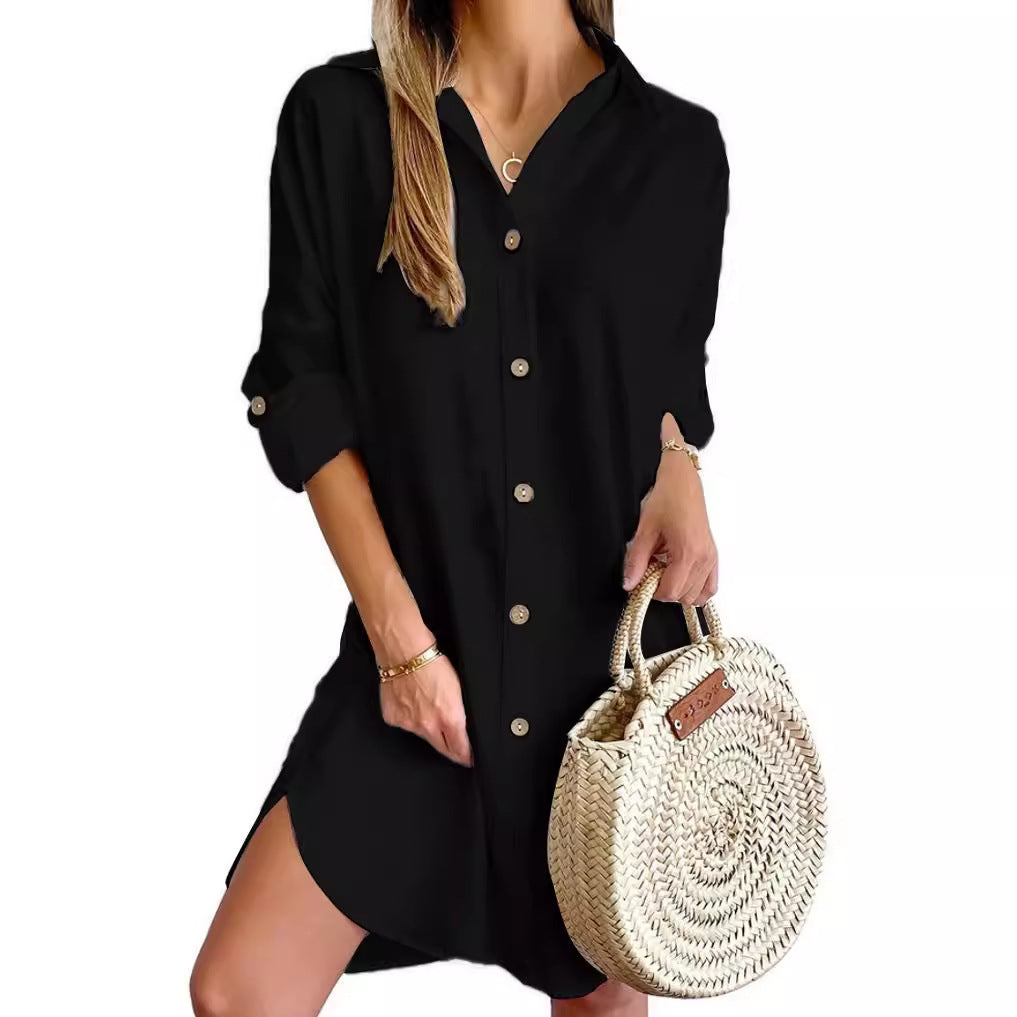 Woman wearing black button-up long sleeve shirt dress holding a round woven straw handbag