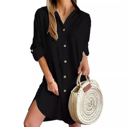 Woman wearing black button-up long sleeve shirt dress holding a round woven straw handbag