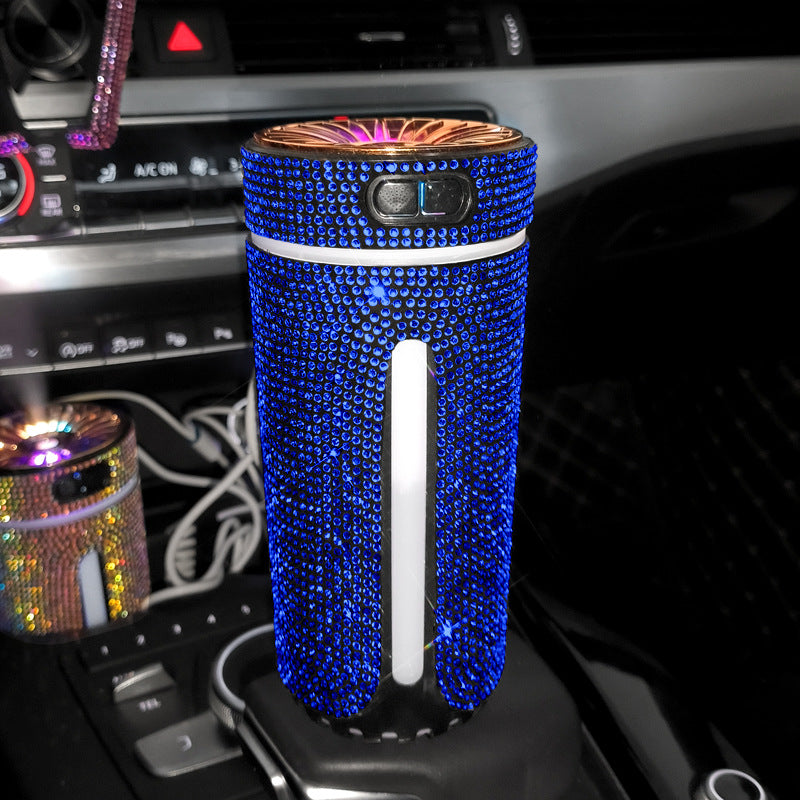 Blue rhinestone-covered car air purifier on vehicle gear shift with dashboard controls visible