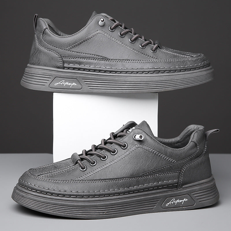 Pair of stylish gray leather casual sneakers with thick soles displayed on white and gray background