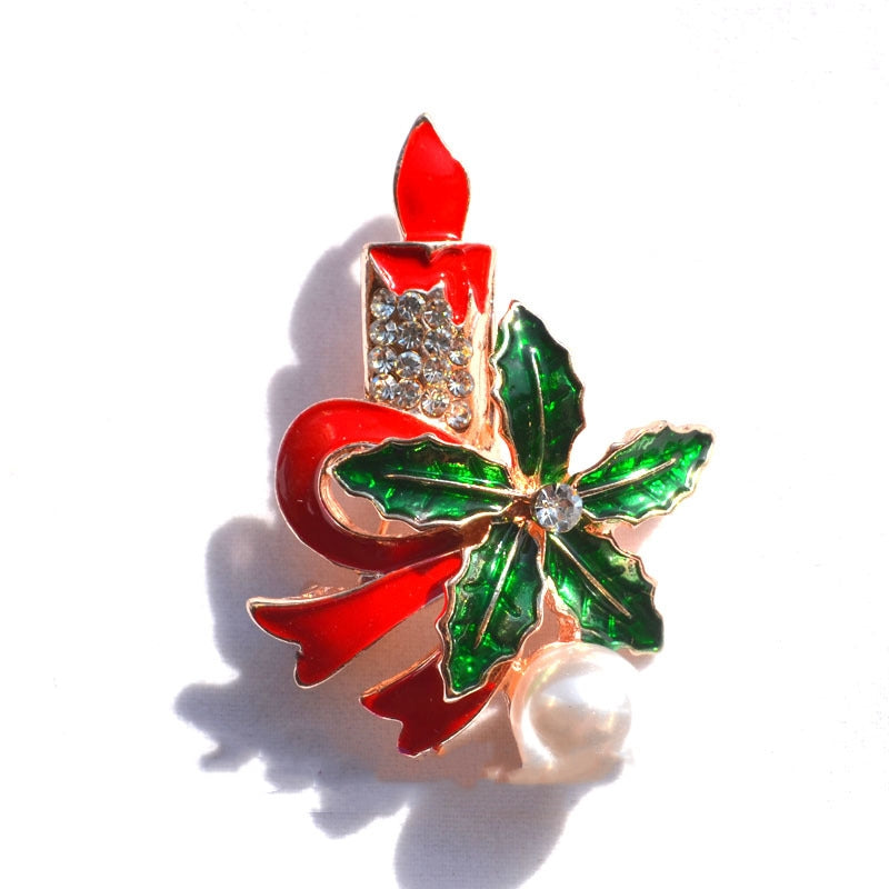 Christmas brooch featuring a red candle with rhinestones, green holly leaves, red ribbon, and a white pearl