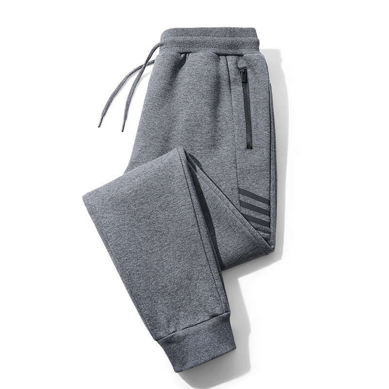 Folded grey casual jogger pants with drawstring waistband, zip pocket, and cuffed ankles