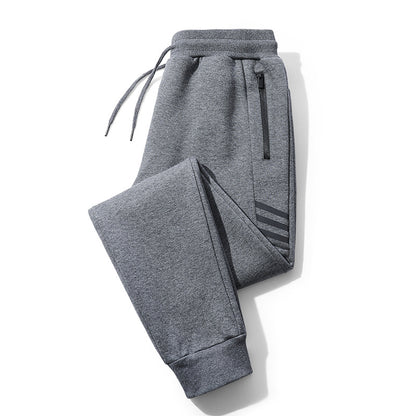 Folded grey casual jogger pants with drawstring waistband, zip pocket, and cuffed ankles