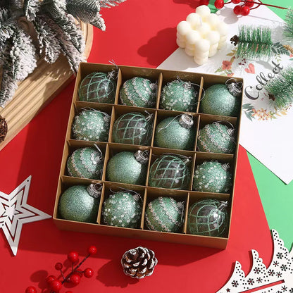 Box of 16 green glittery Christmas ornaments on red table with pinecones and festive decorations
